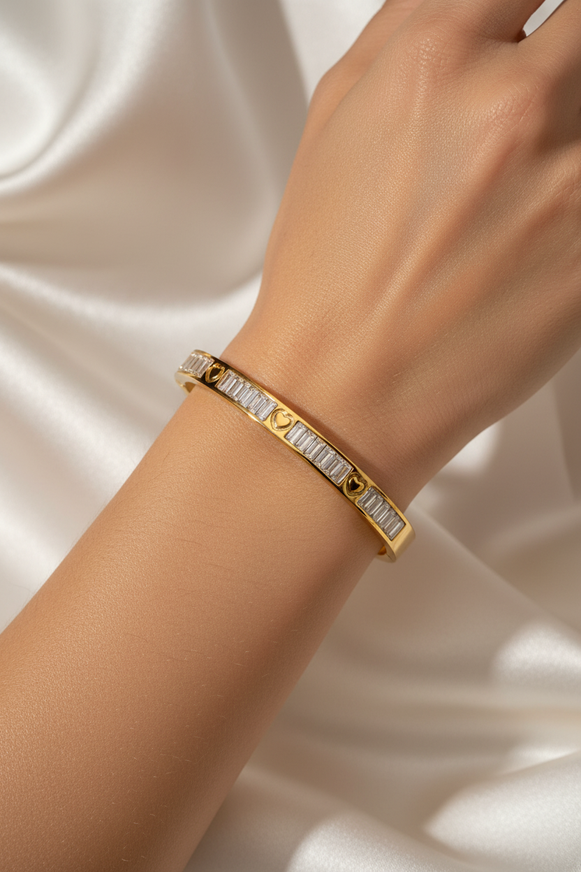 Gold baguette heart bangle on wrist