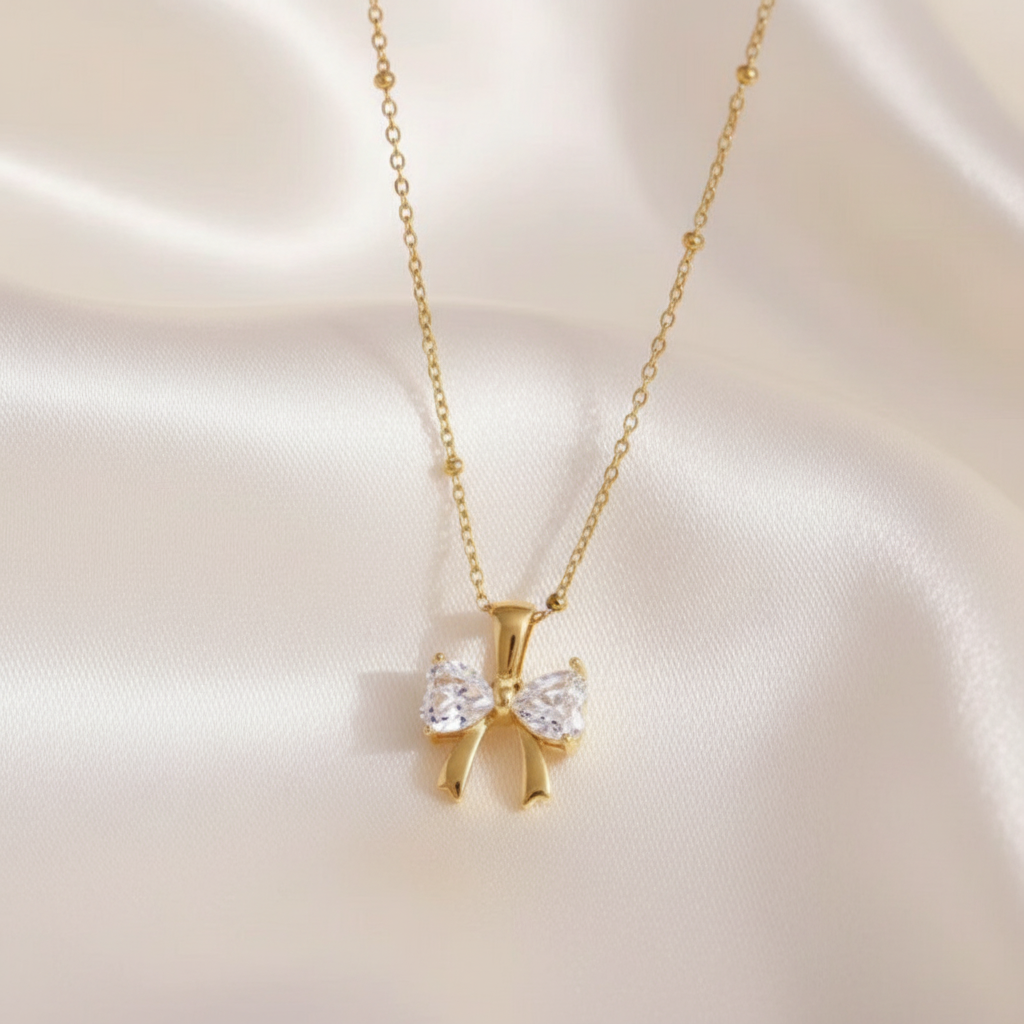Gold bow necklace champagne satin background