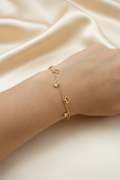 Gold heart charm bracelet on wrist