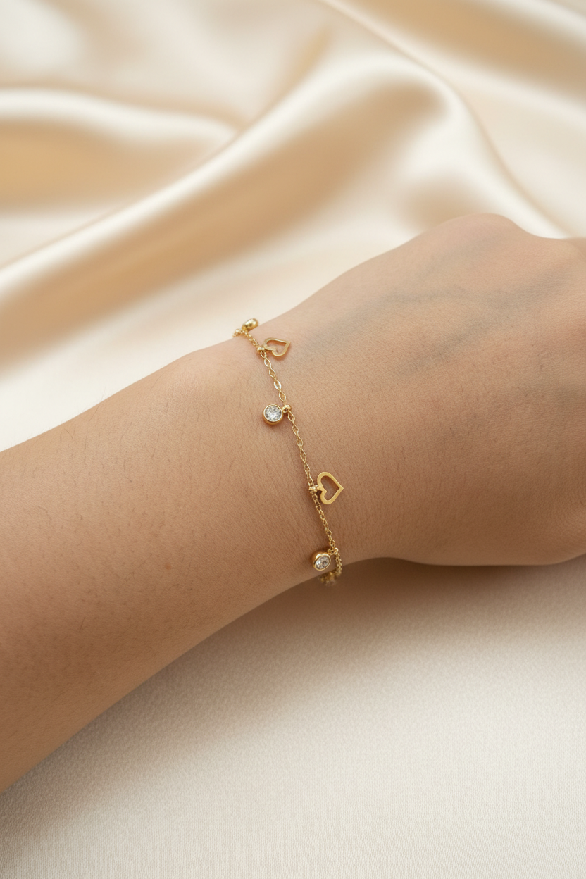 Gold heart charm bracelet on wrist